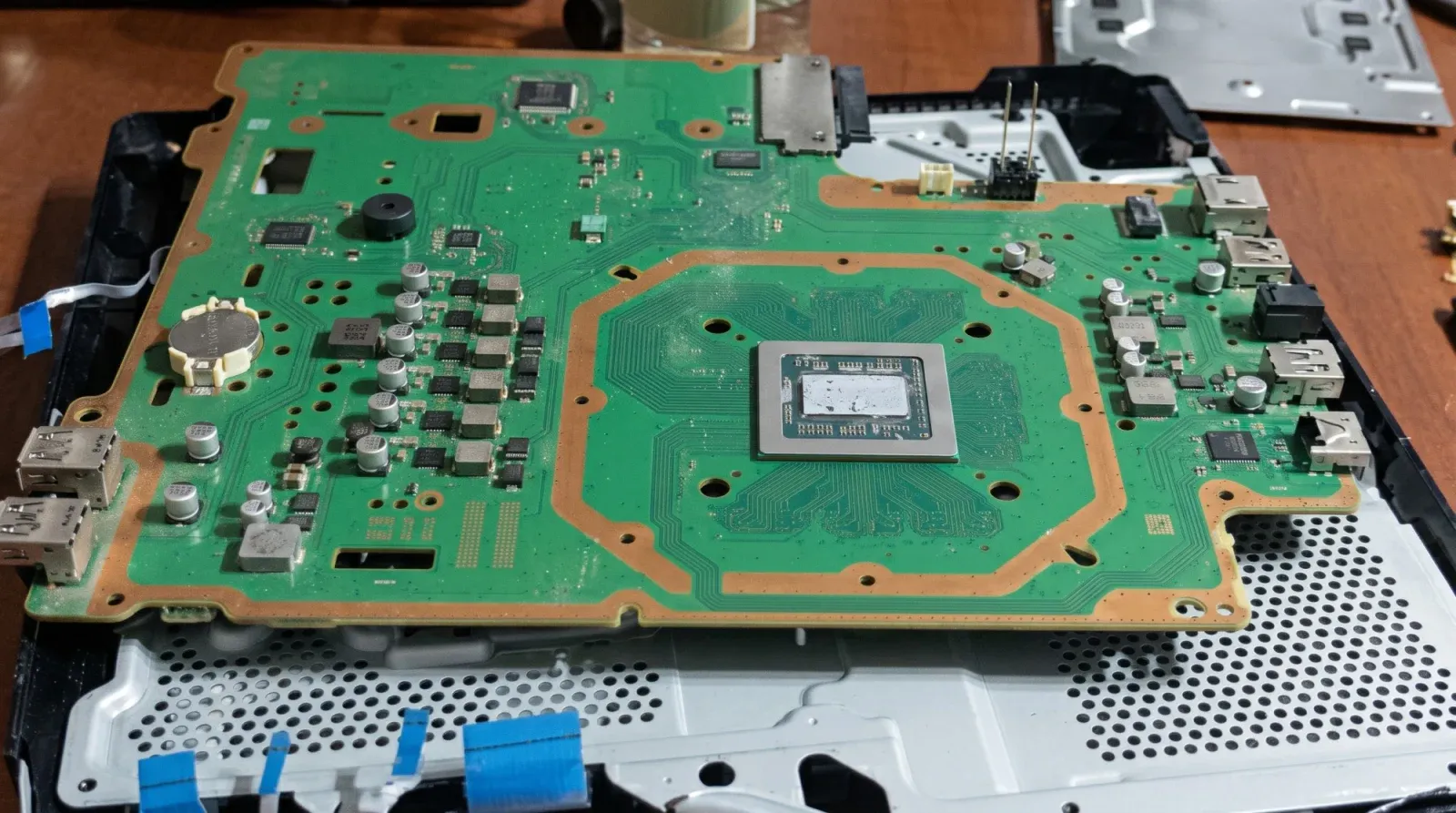 Sökülmüş PS4 anakartı, işlemcinin üzerinde kurumuş ve çatlamış eski termal macun